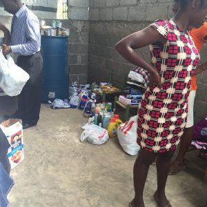 Personal items, like soap, toothpaste, are in tis picture the food is not captured but on a table behind Pasteur Perniel in the back